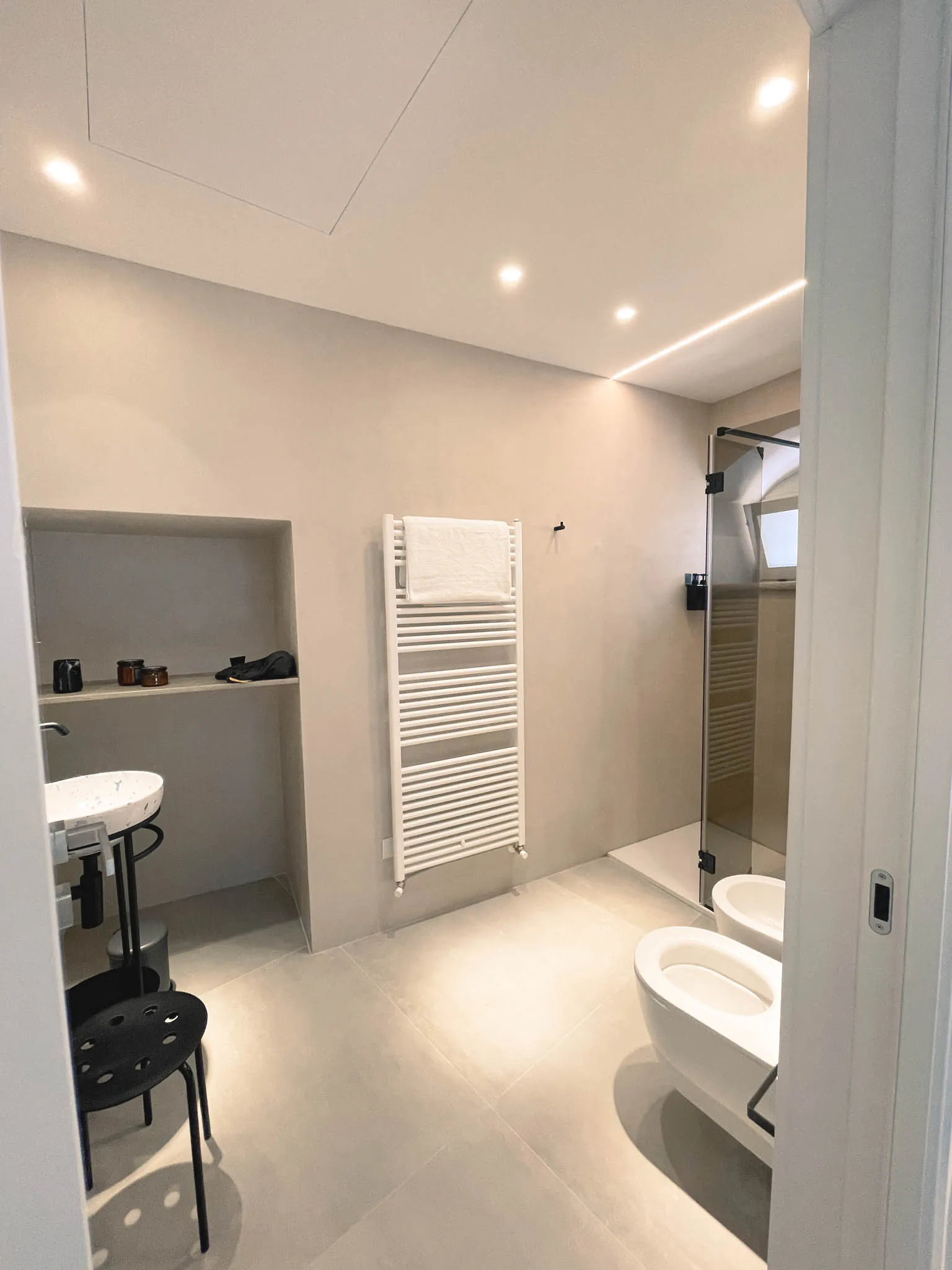 Il bagno della camera Pètra con lavabo tondo su consolle, termoarredo, wc e bidet