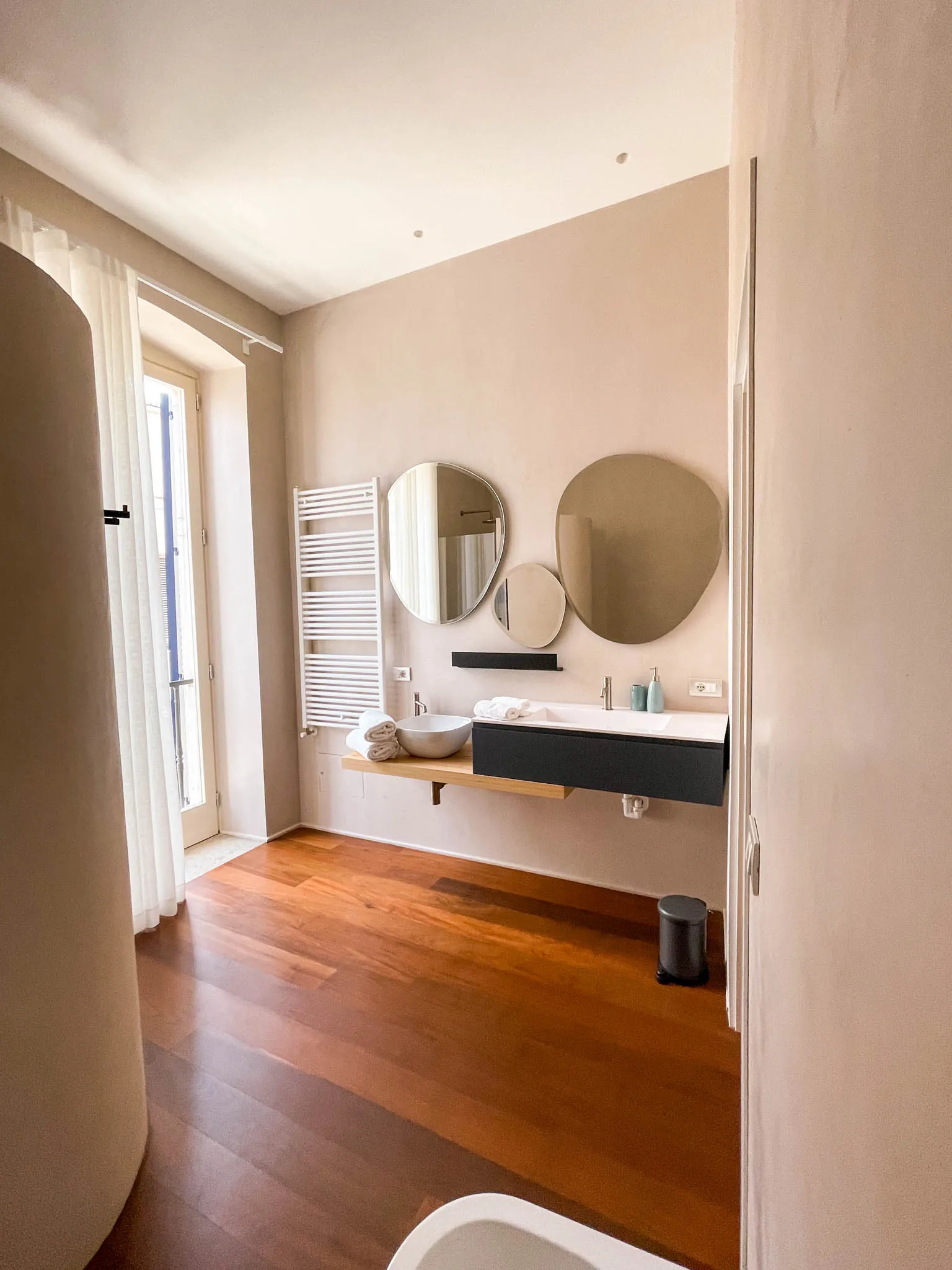 Il bagno della camera Xylo con due specchi tondi e lavabo sospeso