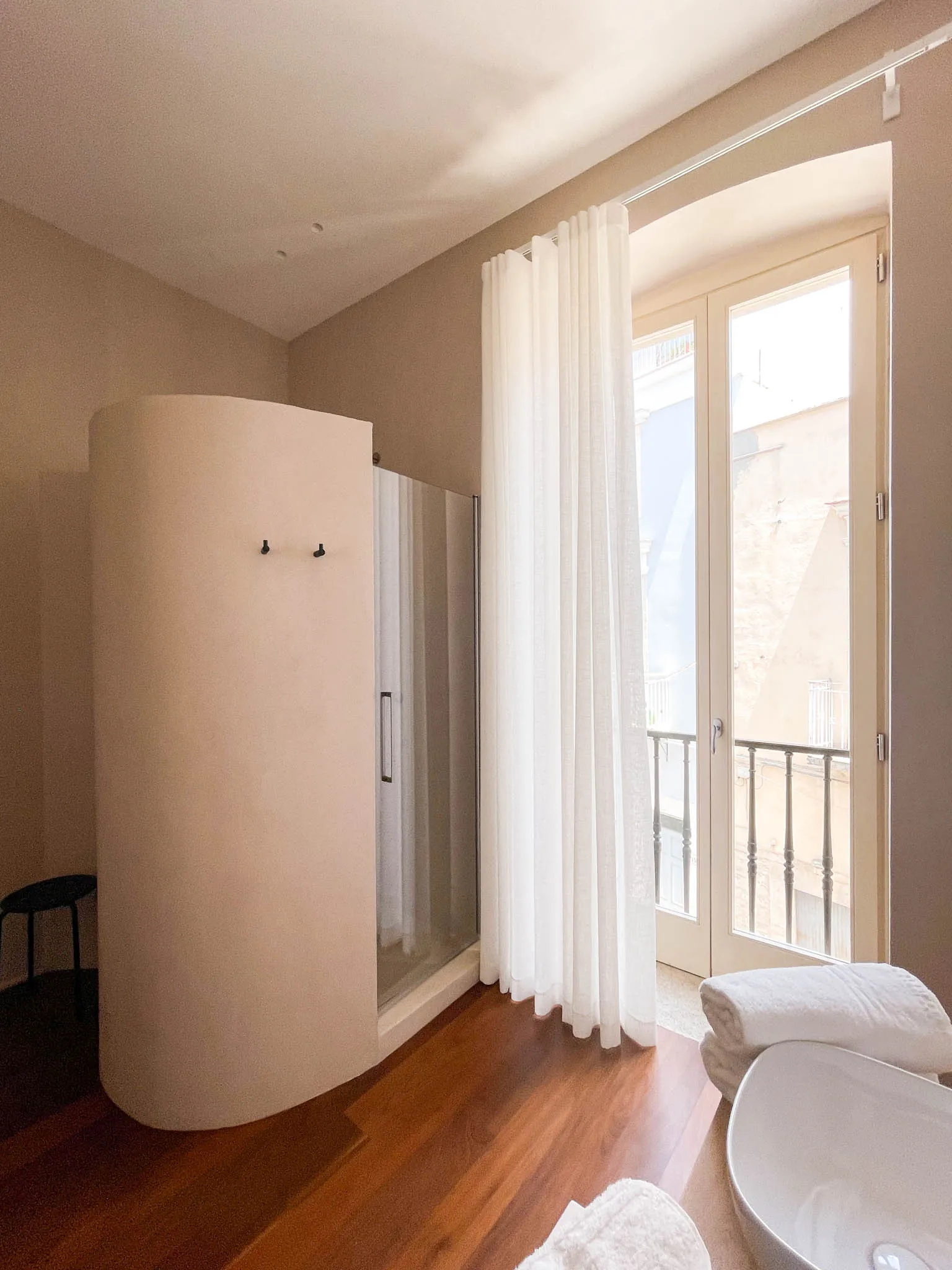 Il bagno della camera Xylo con la doccia dietro la parete curva e la porta-finestra