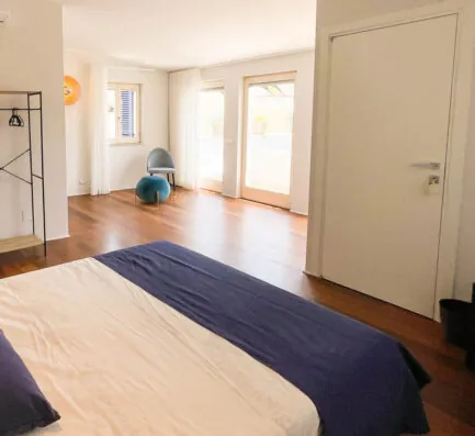 La camera Fos: letto matrimoniale con copriletto blu e porta-finestra sulla terrazza