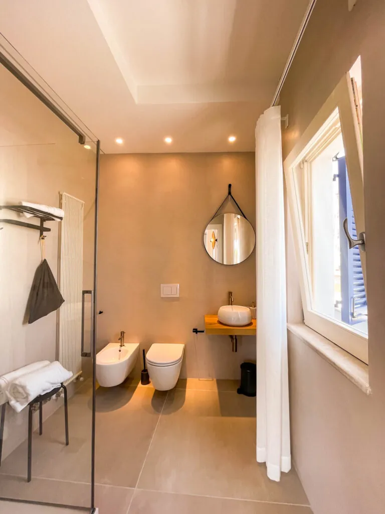Il bagno della camera Fos con specchio tondo, lavabo, wc e bidet
